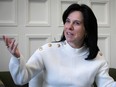 Montreal mayor valerie plante, a white woman with black hair, is seen gesturing with one hand up in this photo, against a beige background. She's wearing a white sweater.