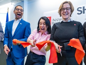 A man and two women are cutting a ribbon at a press conference. From left to right: Lionel Carmant, provincial social services minister, Valerie Plante, mayor of Montreal, and Fiona Crossling, general director of Accueil Bonneau.