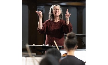 A woman conducts an orchestra.