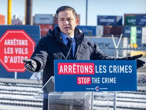 A man (conservative leader pierre poilievre) is standing at a podium behind a poster that reads 'stop the crime.' There are shipping containers in the background and a sign to his left that says, in french, 'stop car thefts.' He's wearing a black jacket and gesturing with his hands out.