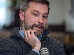 Gabriel Nadeau-Dubois scratches his chin while sitting in front of a microphone