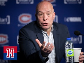 A man gesticulates as he speaks in front of a background with Montreal Canadiens logos