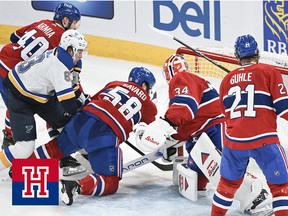 Hockey players scramble in the goaltender's crease