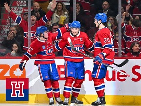 Three Montreal Canadiens players come together to celebrate a goal