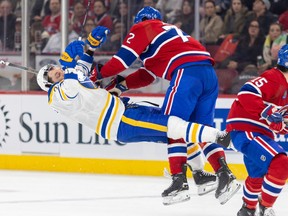 Buffalo Sabres' Zemgus Girgensons flies backwards as he's pushed by Canadiens' Arber Xhekaj