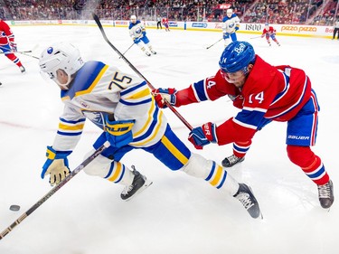 Montreal Canadiens' Nick Suzuki checks Buffalo Sabres' Connor Clifton from behind