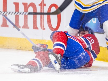 A Sabres player steps over Canadien Joshua Roy lying on the ice