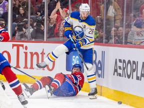 Buffalo Sabres' Zemgus Girgensons steps over Montreal Canadien Joshua Roy to play the puck