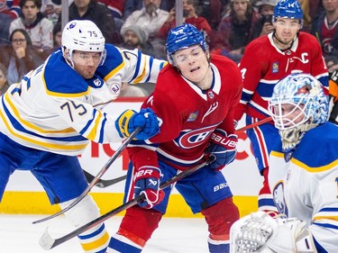 Montreal Canadiens' Cole Caufield takes a crosscheck in the back