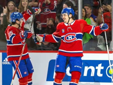 Montreal Canadiens' Arber Xhekaj extends his arms as Alex Newhook skates toward him on the ice