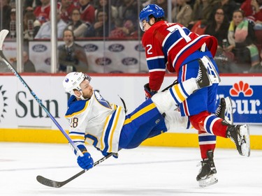 Buffalo Sabres' Zemgus Girgensons flies backwards in front of Canadiens' Arber Xhekaj