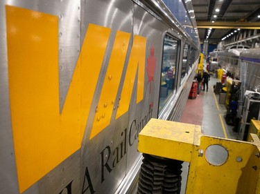 A Via Rail logo on the side of a train car in a maintenance building