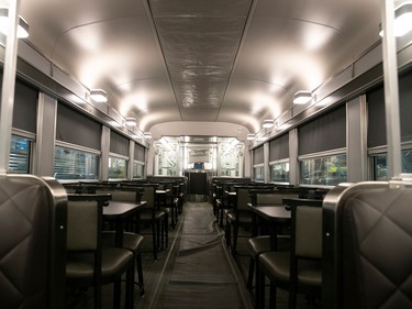 The interior of a renovated grey diner car sits empty.