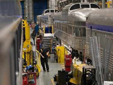 Workers and tools between two trains in a maintenance building