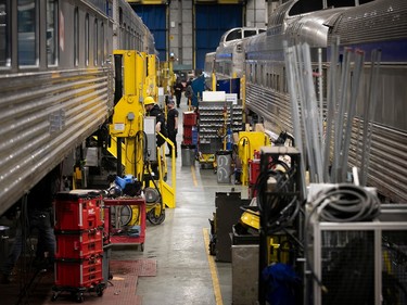 Workers and tools between two trains in a maintenance building