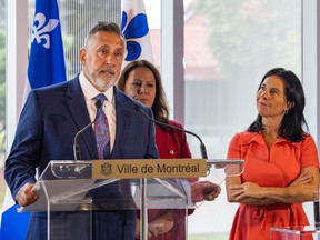 Opposition councillor Jim Beis speaks at a lectern next to Mayor Valérie Plante and Caroline Bourgeois of the executive committee.