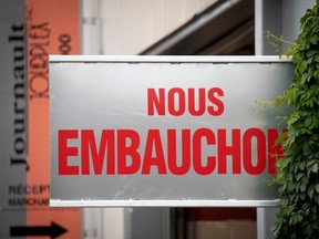 A grey sign reading 'nous embauchons' or (we're hiring, in English) is seen.