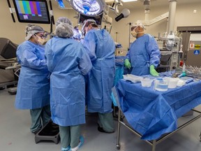 Several medical personnel surround a patient in an operating room.