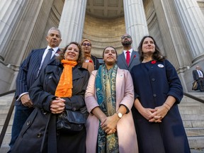 A group of people stand together on the steps of a courthouse building