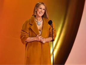 Celine Dion smiles as she stands at the microphone at the Grammys.