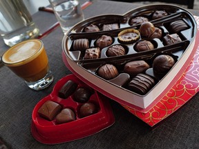 In this photo illustration, chocolates packaged for Valentine's Day sit on a table along with a cup of coffee.