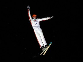 Alexandre Duchaine is lit up in the night sky in the middle of an aerial ski jump