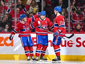 Canadiens' Nick Suzuki, centre, celebrates his goal with linemates Cole Caufield, left, and Juraj Slafkovsky during game last week at the Bell Centre.