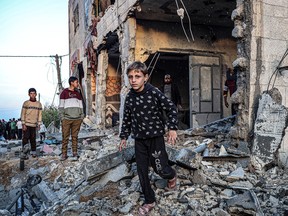 People walk through the rubble of a building heavily damaged by Israeli bombardment, in Rafah in the southern Gaza Strip on Sunday, Feb. 11, 2024, amid the continuing conflict between Israel and the Palestinian militant group Hamas.