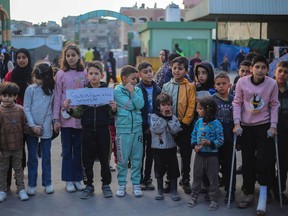 Palestinian children hold placards during a march demanding an end to the war and their right to live, education and play on Feb. 14, 2024 in Rafah, Gaza.