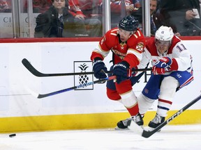 Canadiens' Brendan Gallagher and Florida's Evan Rodrigues fight for position on the ice chasing a puck