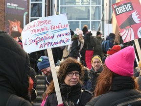A woman is holding a sign at a protest with several people standing behind her. the sign says balancing work and family, inflation impoverishes us.