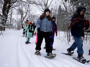 Maria Cortes, centre, a Grade 10 student from Spain, tries snowshoeing for the first time as international students studying at the Lester B. Pearson School Board get a taste of winter at Beaver Lake, in Montreal, on Sunday, Feb. 18, 2024.