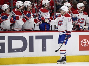 Canadiens captain Nick Suzuki gets high-fives from teammates as he skates past the Montreal bench after scoringhis second goal of the game.
