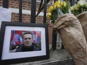 Flowers and a photo are left opposite the Russian Embassy in London, Friday, Feb. 16, 2024, in reaction to the news that Navalny has died in a Russian prison, according to the Federal Penitentiary Service.