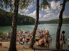 People enjoy the warm weather by a lake near Vilnius, Lithuania, Aug. 17, 2023.