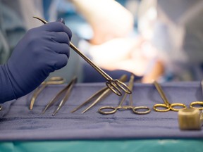Surgical instruments are seen on an operating room table