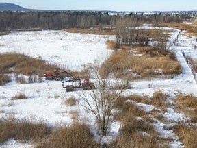 Aerial view of construction in a forested area with snow on the ground.