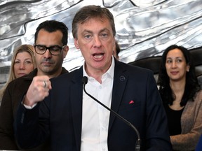 A man gestures with his fist during a press conference.