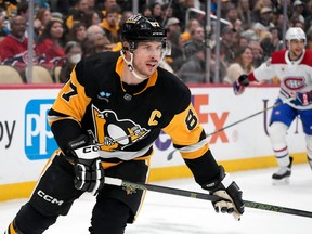 Penguins superstar is seen with his head up and stick in both hands while skating in a game against the Canadiens.