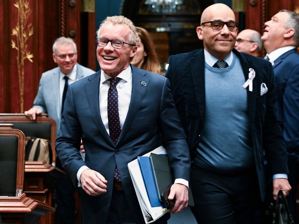 Quebec Labour Minister Jean Boulet arrives to present  legislation on construction, Thursday, Feb. 1, 2024 at the legislature in Quebec City. Quebec Minister for the Economy, Minister Responsible for the Fight Against Racism Christopher Skeete, right, walks along.