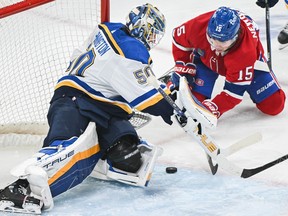 Canadiens' Alex Newhook (15) moves in on St. Louis Blues goaltender Jordan Binnington during first period NHL hockey action in Montreal, Sunday, Feb. 11, 2024.