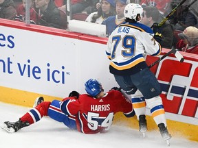 Canadiens' Jordan Harris (54) is checked into the boards by St. Louis Blues' Sammy Blais during first period NHL hockey action in Montreal, Sunday, Feb. 11, 2024.