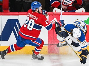 Canadiens' Juraj Slafkovsky (20) checks St. Louis Blues' Oskar Sundqvist during second period NHL hockey action in Montreal, Sunday, Feb. 11, 2024.
