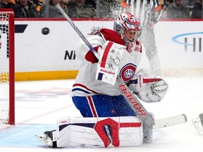 Montreal Canadiens goaltender Cayden Primeau is on his knees in his crease as a puck flies by his head toward the net