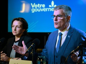 Eric Caire speaks at a table during a news conference next to Chantal Garcia