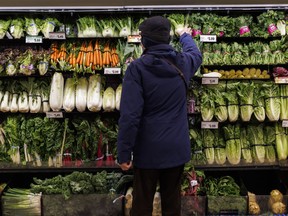 A customer shops for produce at a grocery store In Toronto on Friday, Feb. 2, 2024.