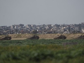 Israeli tanks move on an area at the Israeli-Gaza border, as seen from southern Israel, Thursday, Feb. 15, 2024.