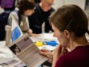 At a letter-writing campaign held Sunday, Feb. 25, 2024 at the Musée d’art contemporain de Montréal, Katia Bushueva reads information on Irina Mohytych, a Ukrainian woman who was arrested while living in Russia.
