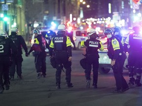 Police patrol Ste-Catherine Street in Montreal, Monday, April 12, 2021, during an 8 p.m. curfew imposed by the Quebec government to help curb the spread of COVID-19, as the COVID-19 pandemic continues in Canada and around the world.