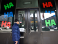 A man peers through a door surrounded by "HA HA HA" signs